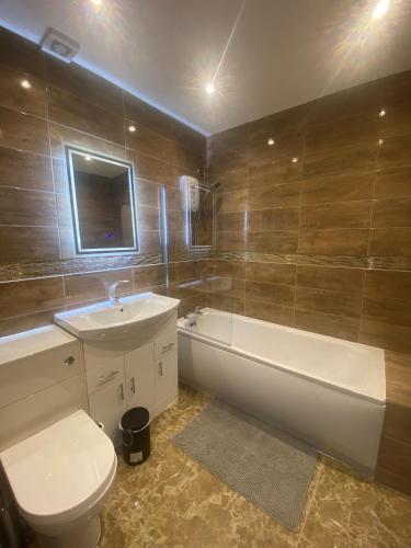 a bathroom with a toilet and a sink and a tub at Jackson Holiday Apartments in Blackpool