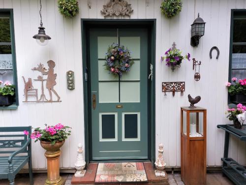 a green door on a white house with flowers at Gastehaus HH- Winterhude in Hamburg