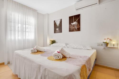 biała sypialnia z łóżkiem i ręcznikami w obiekcie Imperial Puerto 2 3F By IVI Real Estate w mieście Torremolinos