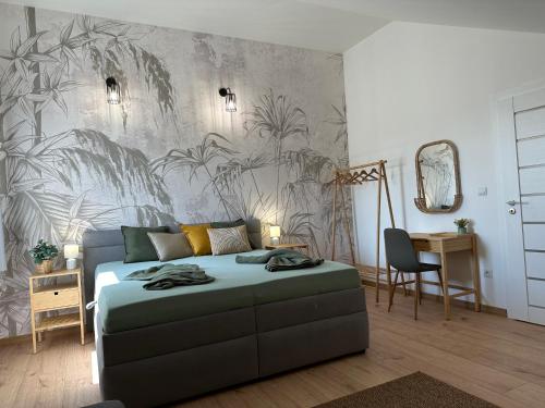 a bedroom with a bed and a wall with plants at GREEN Apartment – City Centre – Main Square in Liptovský Mikuláš