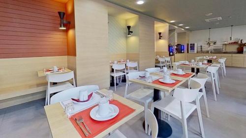 un restaurant avec des tables blanches et des chaises blanches dans l'établissement La vie en bleu - Studio proche de Paris, à Charenton-le-Pont