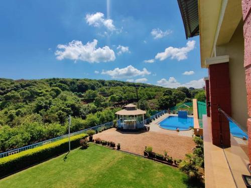 an aerial view of a house with a swimming pool and a yard at Khushi Riverside Resort & Spa in Mahabaleshwar