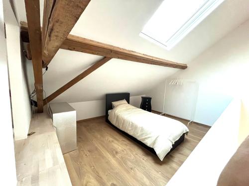 1 dormitorio con cama blanca y tragaluz en L'escale en Enghien