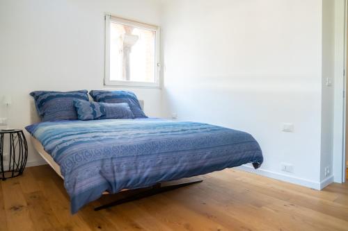 een bed met een blauw dekbed in een slaapkamer bij Casa dell'Arengo in Grado