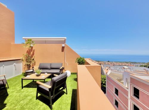 a patio with a table and chairs on a roof at The Valley View Apartments in La Orotava