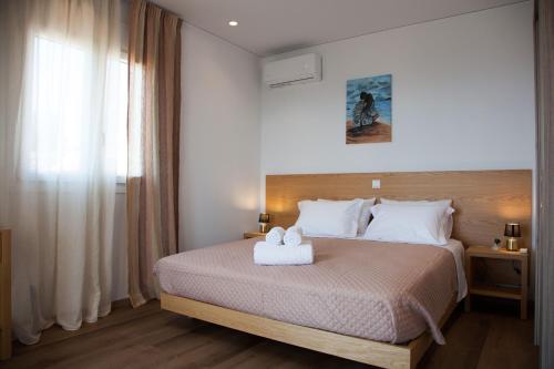 Un dormitorio con una cama con una toalla blanca. en Villa Anthodesmi en Dilináta