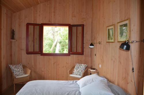 une chambre avec un lit et une fenêtre dans l'établissement Maison bois 10 pers CapFerret Plage des Américains, à Lège-Cap-Ferret