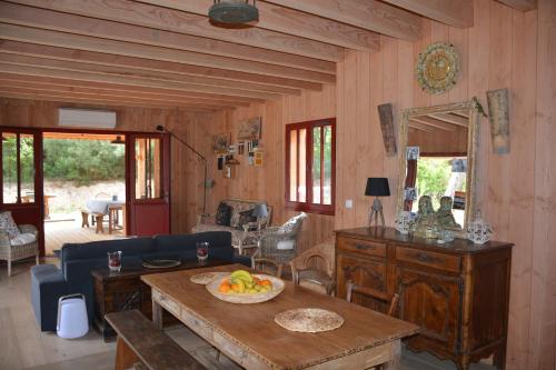un salon avec une table avec un bol de fruits dessus dans l'établissement Maison bois 10 pers CapFerret Plage des Américains, à Lège-Cap-Ferret