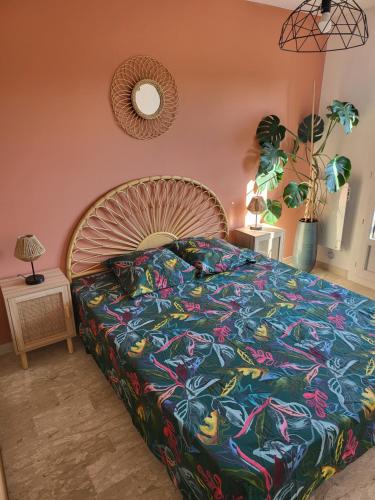 a bedroom with a large bed with a colorful bedspread at Appart refait à neuf 800m port de Sanary sur Mer in Sanary-sur-Mer