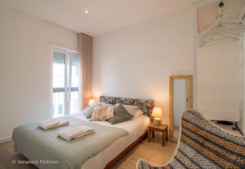 a bedroom with a bed with two towels on it at Nesha Ericeira Flats in Ericeira