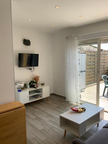 un salon avec un canapé et une télévision sur un mur dans l'établissement Sunny studio - Magnan, Tramway-Proche aéroport, à Nice