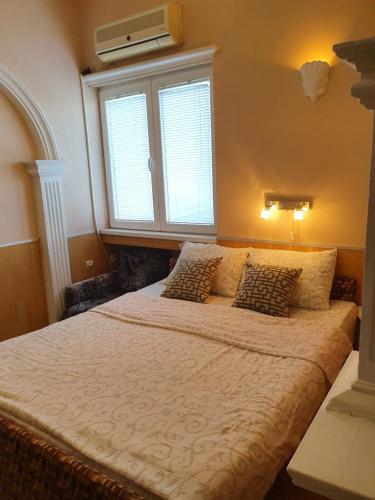 Schlafzimmer mit einem großen Bett und einem Fenster in der Unterkunft Malgo in Vrnjačka Banja