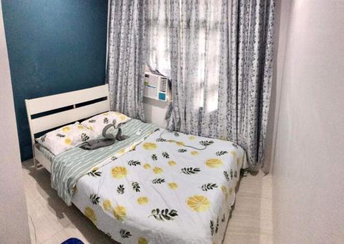 Un pequeño dormitorio con una cama con flores amarillas. en CCJ Villa, en Bacolod