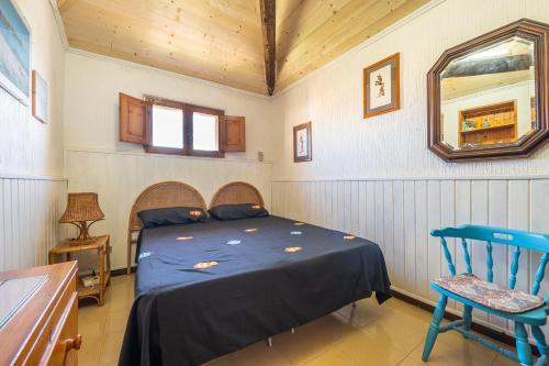 ein Schlafzimmer mit einem Bett und einem blauen Stuhl in der Unterkunft Villa Ondina 1 Carloforte in Carloforte