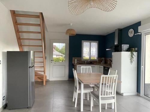 uma cozinha com uma mesa e cadeiras e um frigorífico em Gites Les Mondaines - Les hirondelles em Favières