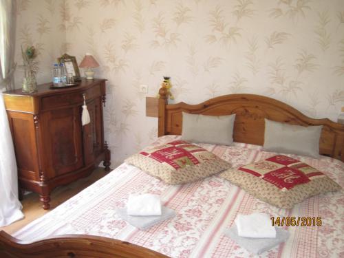 a bedroom with a bed with two pillows on it at Hotel Le Commerce in Neuville