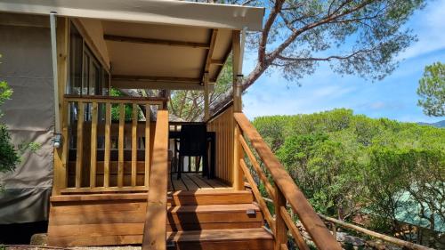 a house with a wooden staircase leading to a porch at Camping Lacona Pineta in Capoliveri