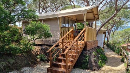 a tree house with a staircase leading up to it at Camping Lacona Pineta in Capoliveri