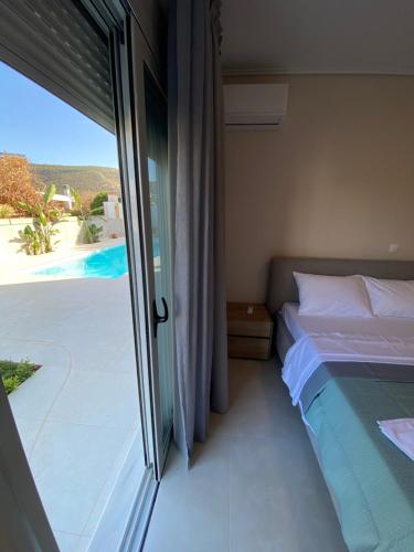 a bedroom with a bed and a sliding glass door at Porto Rafti Dream Complex & Retreat in Porto Rafti