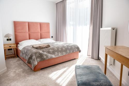 um quarto com uma cama e uma grande janela em Pinea Apartament 304 Apartament przy plaży em Pobierowo