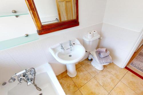 uma casa de banho com um lavatório, um WC e um espelho. em CROYDE HALLGREIN 4 Bedrooms em Croyde