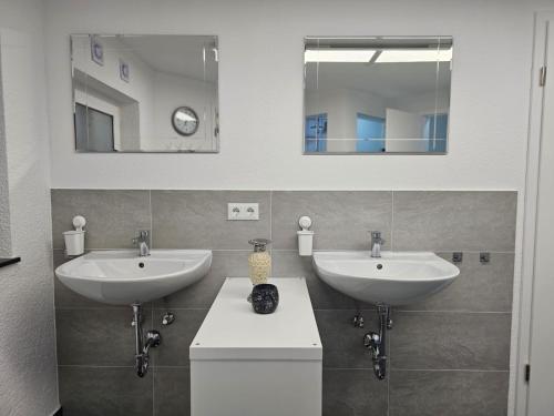 a bathroom with two sinks and two mirrors at ELW sonnig,Terasse, bis zu 13 Schlafpl. in Obergröningen