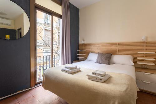 - une chambre avec un lit et des serviettes dans l'établissement Mambo Tango, à Barcelone
