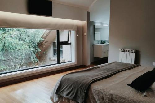 a bedroom with a bed and a large window at Gran casa pareada con piscina en Vigo. Playa: 9min in Vigo