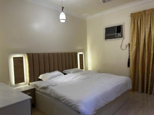 sypialnia z dużym białym łóżkiem i oknem w obiekcie شقق السلام w Medynie
