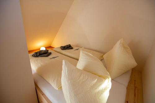 a bedroom with a bed with white sheets and pillows at NaturparkResort GeoApartment in Gams bei Hieflau