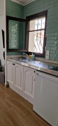una cucina con lavandino e finestra di En Denia, urbanización el palmar con piscina, toboganes y chiringuito a Denia