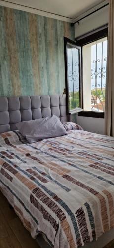 un grande letto in una camera da letto con finestra di En Denia, urbanización el palmar con piscina, toboganes y chiringuito a Denia