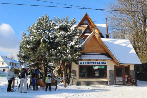 a group of people standing in the snow outside a store at U Maćka in Białka Tatrzańska