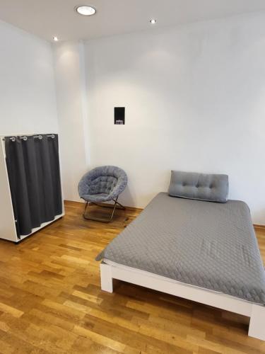 a bed and a chair in a room at Apartment Pette C40 in Berlin
