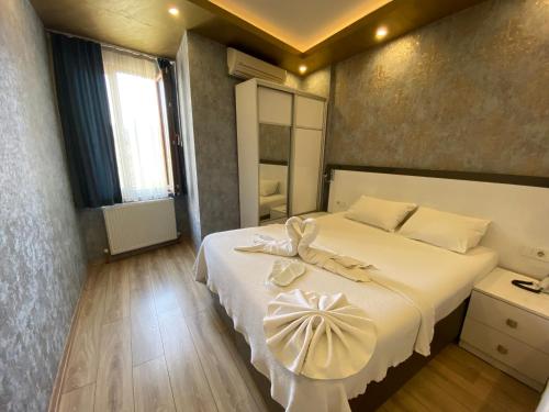 een slaapkamer met een groot wit bed met een boog erop bij DVHOTEL in Istanbul
