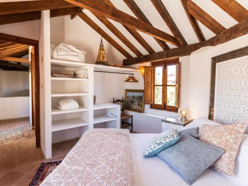 a bedroom with a bed in a room with wooden ceilings at Molino Bajo in Melegis