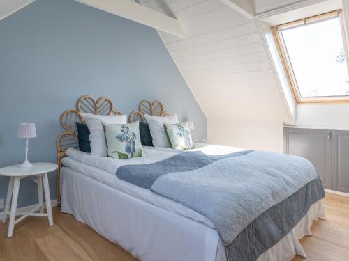 a bedroom with a bed with a blue blanket and a window at Sjælegård Countryside Lodge in Allinge