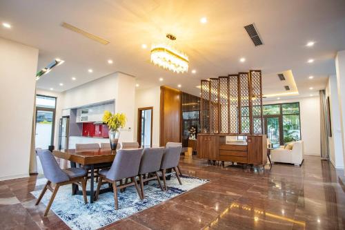 a dining room and living room with a table and chairs at FLC Grand Villa BT33-04 in Sầm Sơn