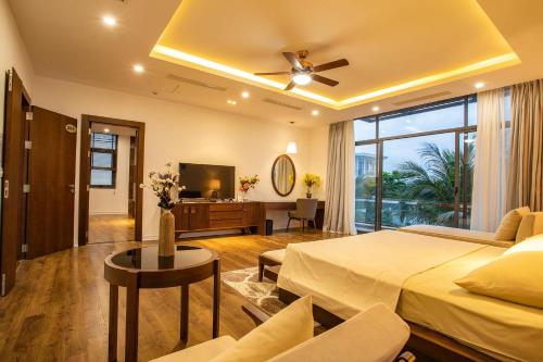 a bedroom with a bed and a living room at FLC Grand Villa BT33-04 in Sầm Sơn