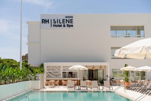 a swimming pool with chairs and a hotel and spa at RH Silene Hotel & Spa 4 Sup in Castellón de la Plana