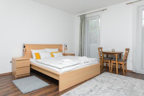 ein Schlafzimmer mit einem großen Bett und einem Tisch in der Unterkunft WestSide Apartments by UrbanRent in Budapest
