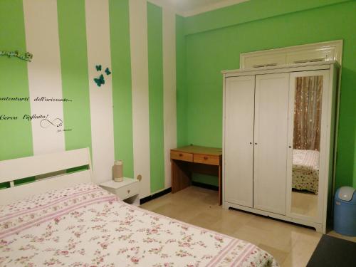 een slaapkamer met groene muren en een bed en een kast bij Céline in Genua