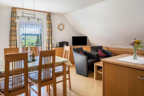 a kitchen and living room with a table and a couch at Waldesruh in Titisee-Neustadt