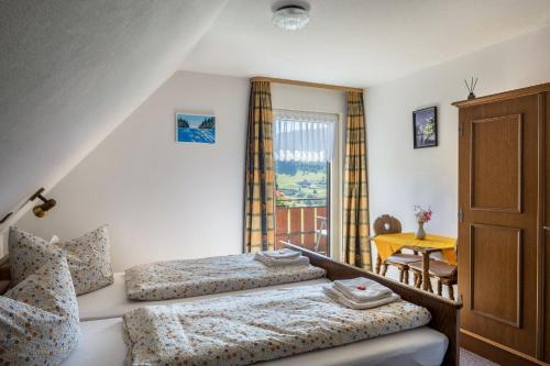 - une chambre avec 2 lits, une table et une fenêtre dans l'établissement Waldesruh, à Titisee-Neustadt