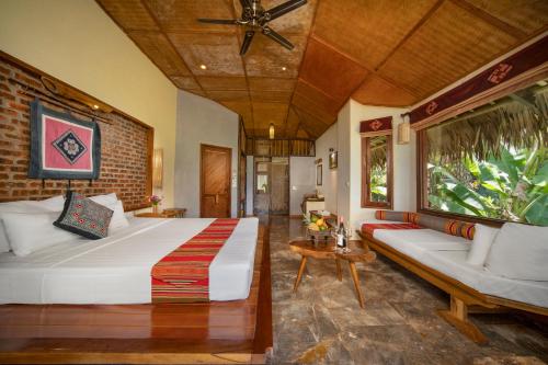 Pu Luong的住宿－浦項度假村，卧室配有一张白色的大床和一张沙发。