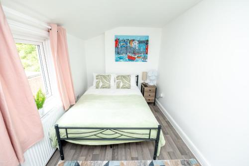 a small bedroom with a bed and a window at Brinton's Road - Modern Studio Apartments in City Centre in Southampton