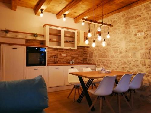 cocina con mesa de madera y sillas en una habitación en Apartments Dalmatian Stone House, en Turanj