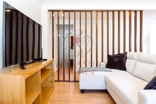 a living room with a couch and a flat screen tv at Cancela Velha Guest•House in Marco de Canaveses