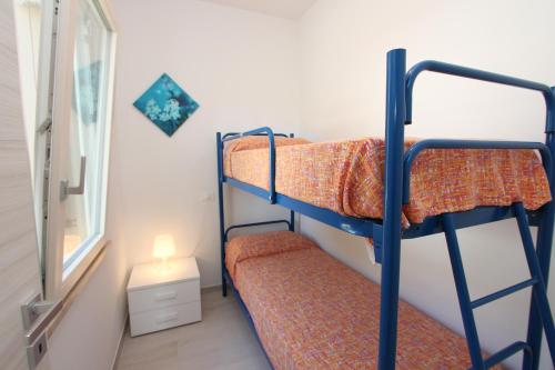een kamer met 2 stapelbedden en een raam bij Ville Pinetine in Bibione