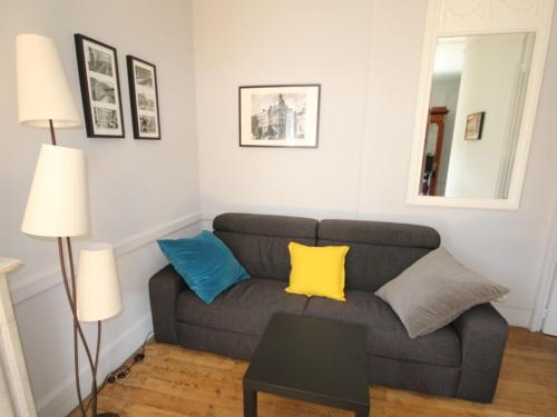 - un salon avec un canapé gris et des oreillers colorés dans l'établissement T1 splendide avec balcon et WIFI - 4 personnes - FR-1-608-46, à Le Mont-Dore